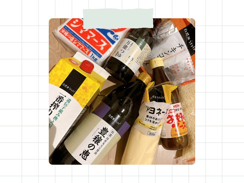 木の床に、しょうゆ、マヨネーズ、お好みソース、塩などの調味料や食材を並べた写真